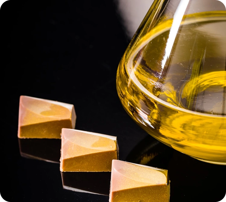 Parlak siyah arka planda gourmet tatlı küpleriyle şık zeytinyağı sunumu.